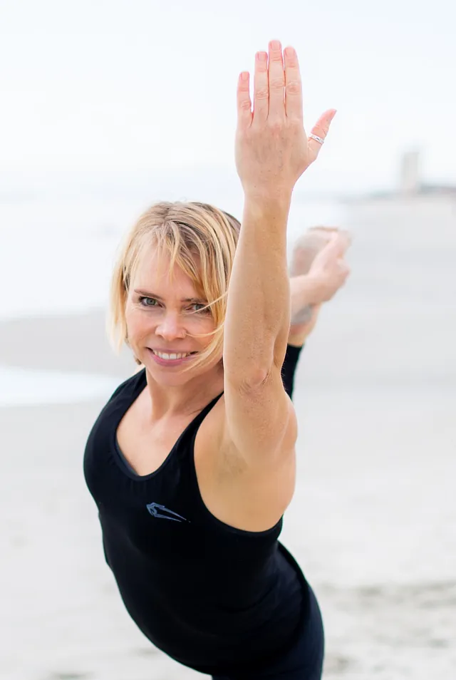 Rie dyrker yoga på strand